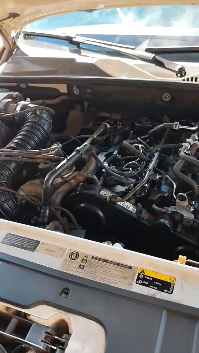 Mecânico trabalhando no motor com o capô aberto